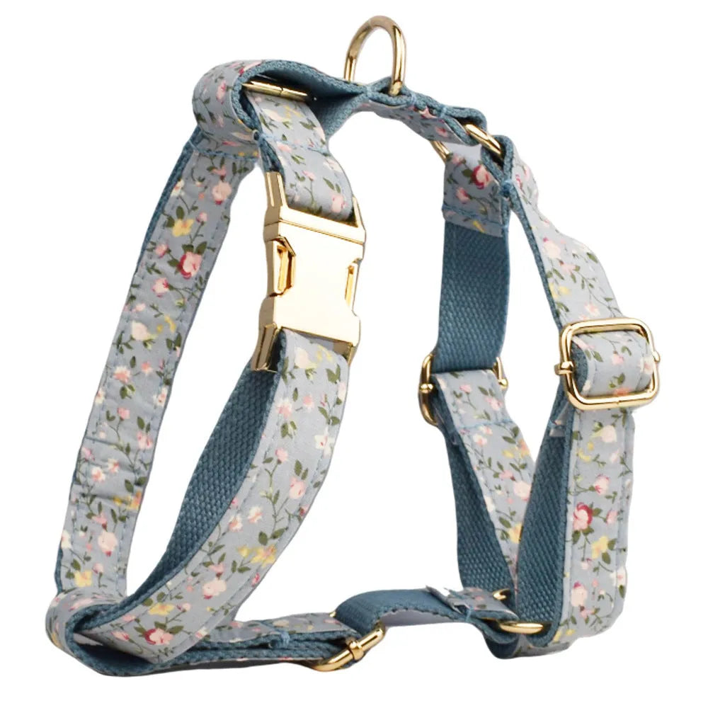 Floral print dog collar and leash set with matching bow, vest, and poop bag holder.