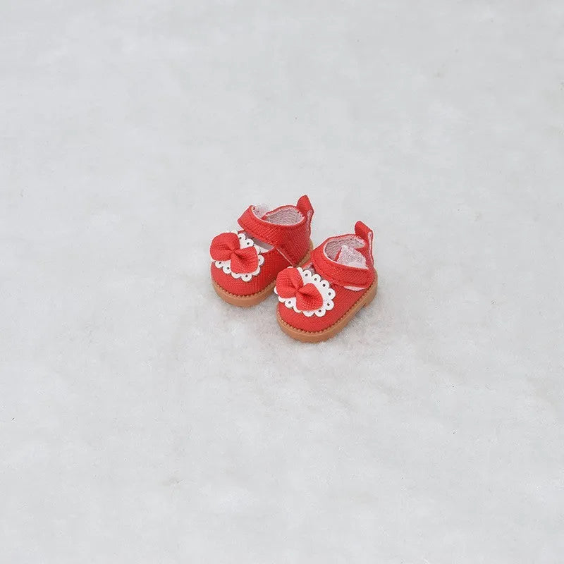 A pair of 17 cm high black doll shoes made from PU leather, shown as a keychain accessory.
