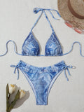 Denim blue women's bikini set with printed design and strap details laid flat.
