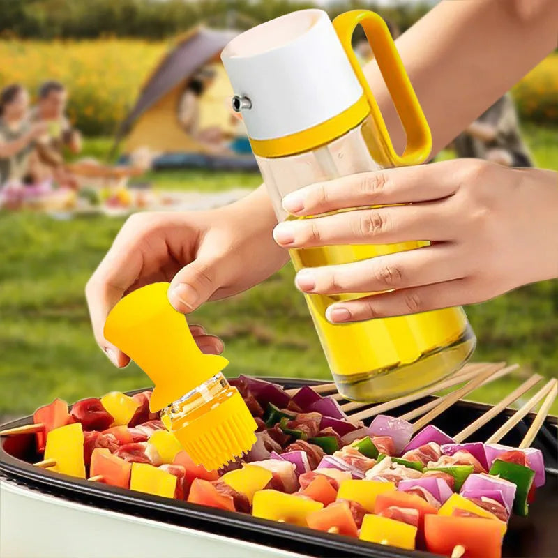 550ml clear glass oil dispenser bottle with stainless steel spray nozzle and a yellow silicone brush head attached.