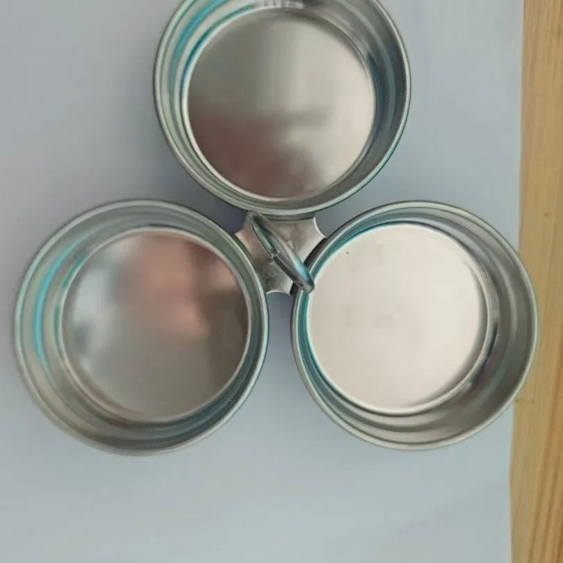 Mini heart-shaped and round stainless steel egg steamer with cooker base on a kitchen counter.