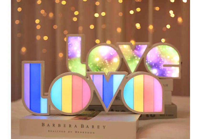 Rainbow coloured LED LOVE word light for Valentine's Day and wedding decoration on a table.