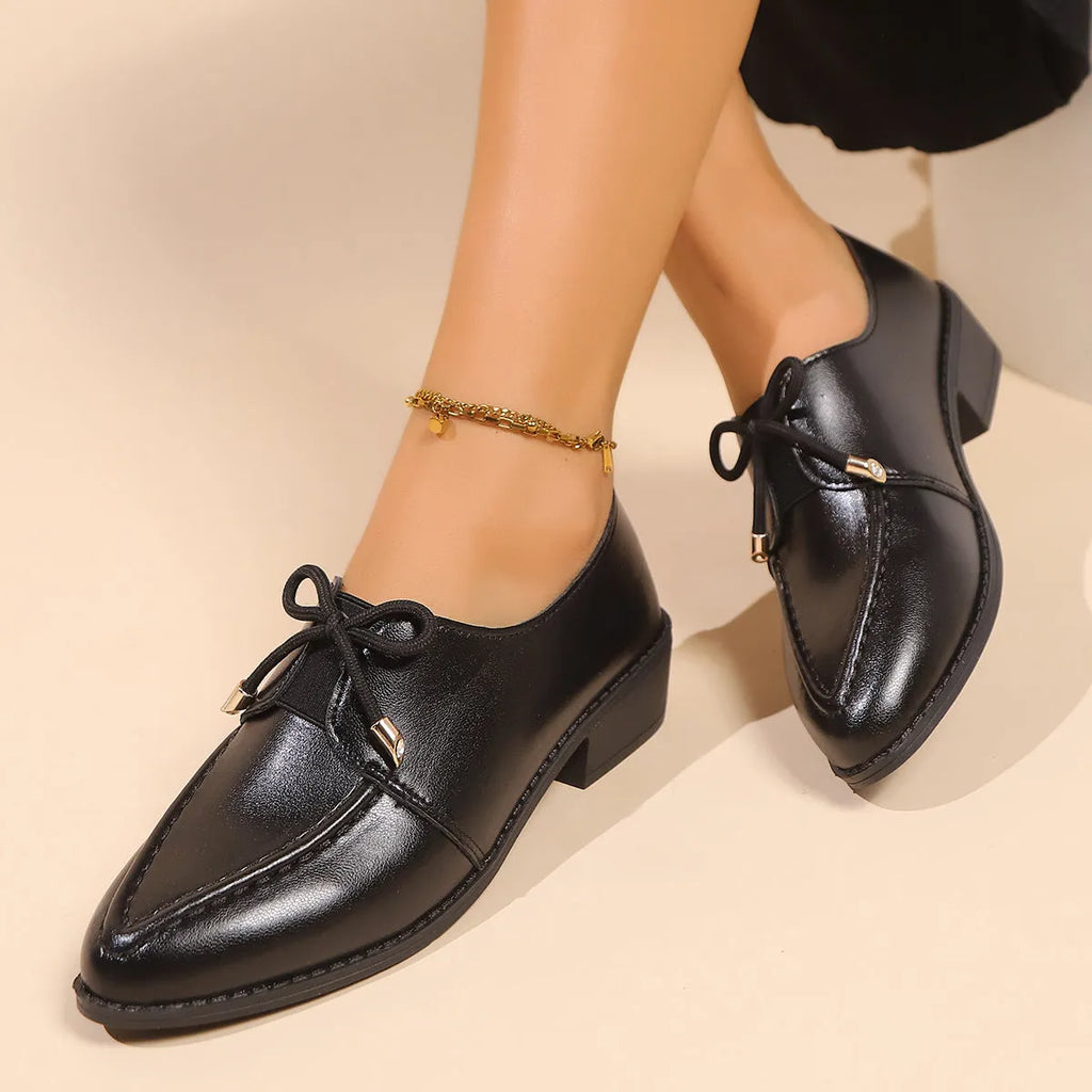 Women's simple leather-look shoes with a decorative bow, on a rubber sole.