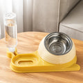 Brown elevated cat food bowl with attached water bottle dispenser on a white background.