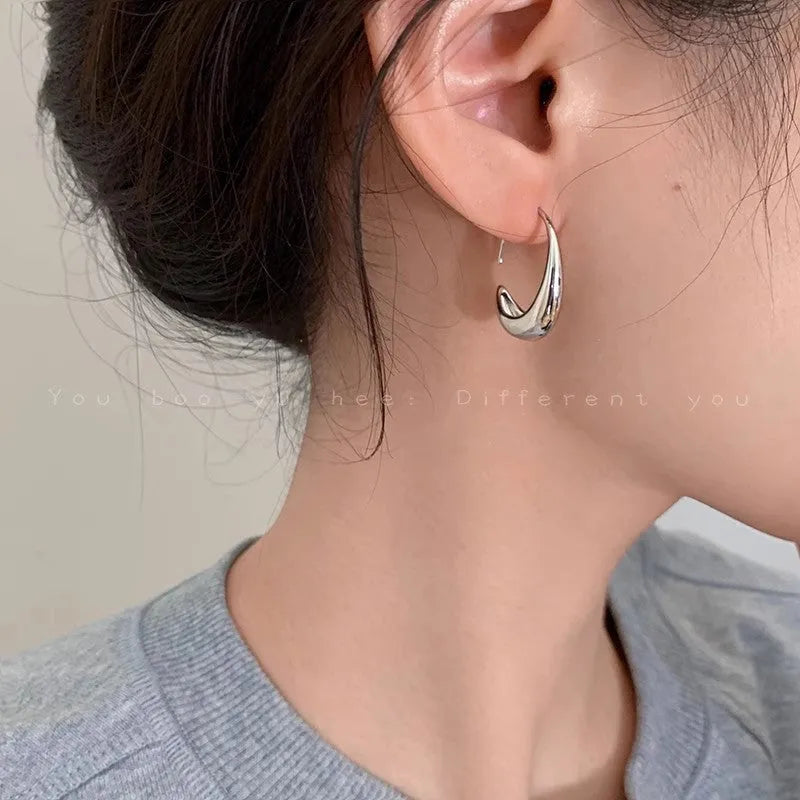 Teardrop hoop earrings in gold or silver tone alloy with C-shaped geometric design, one pair
