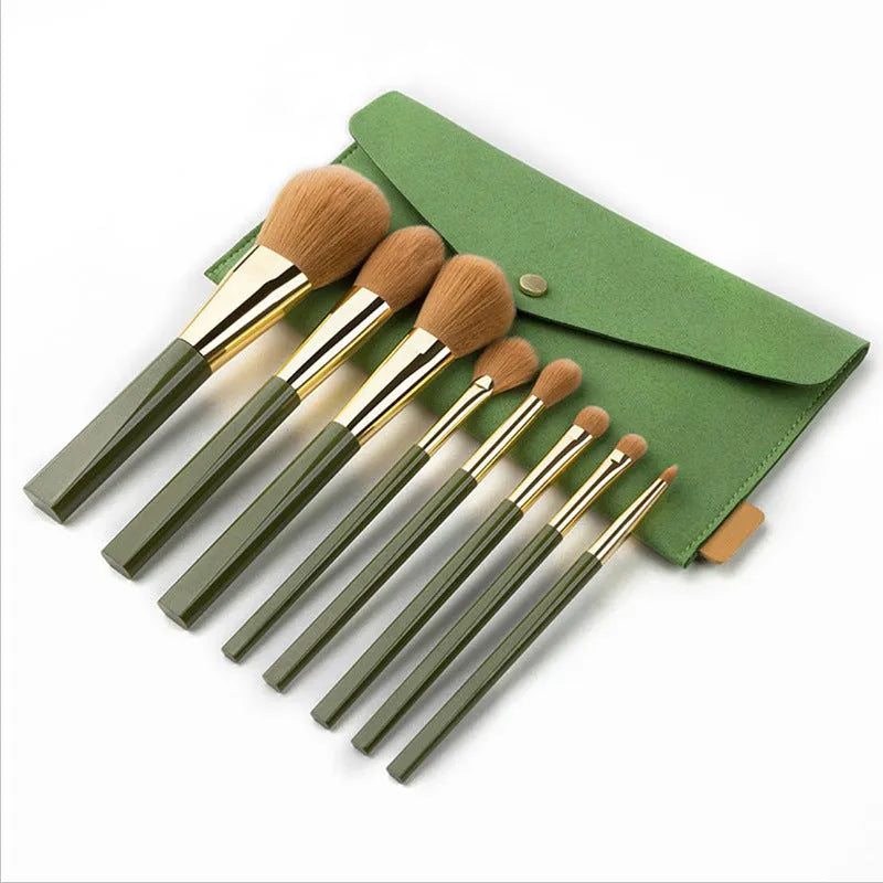 8-piece makeup brush set with man-made fibre bristles, wood handles, 17cm total length, and green shimmering PU bag