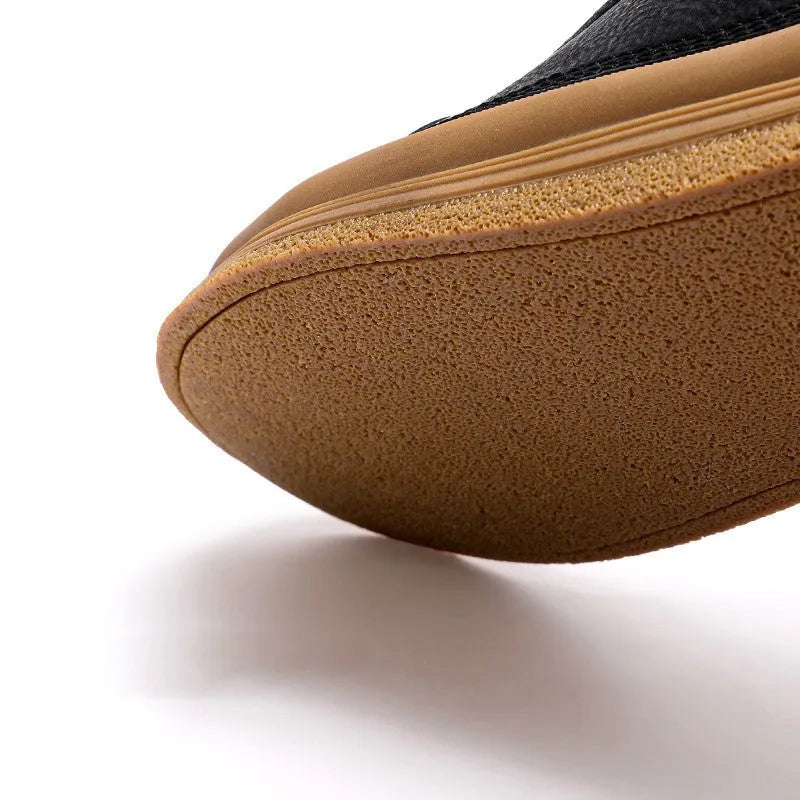 Men's black casual leather shoes with round toe and white rubber sole on a plain background.