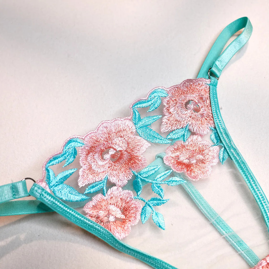 Pink women's bikini set with embroidered mesh pettiskirt and matching strappy top.