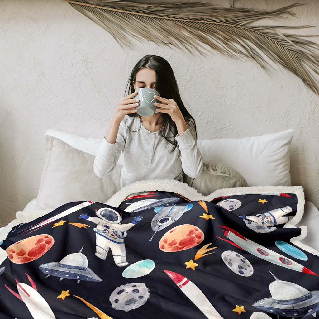 Black astronaut themed sherpa fleece blanket with hemmed edges, available in 130x150cm and 150x200cm sizes.