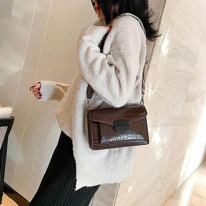 A PU fabric crossbody bag with an adjustable strap, shown in dark brown colour.
