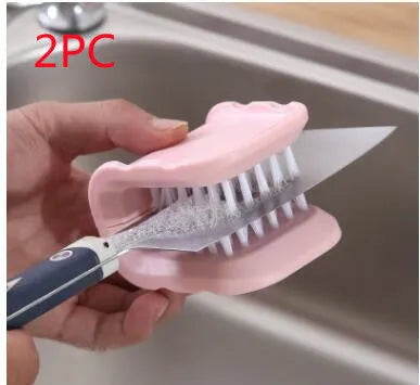 Blue U-shaped plastic brush for cleaning kitchen knives and forks on a draining board.