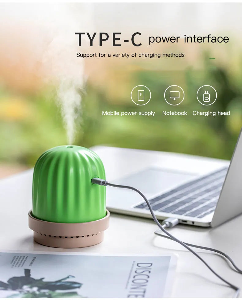 Cactus humidifier night light in green with colourful LED glow on a wooden desk