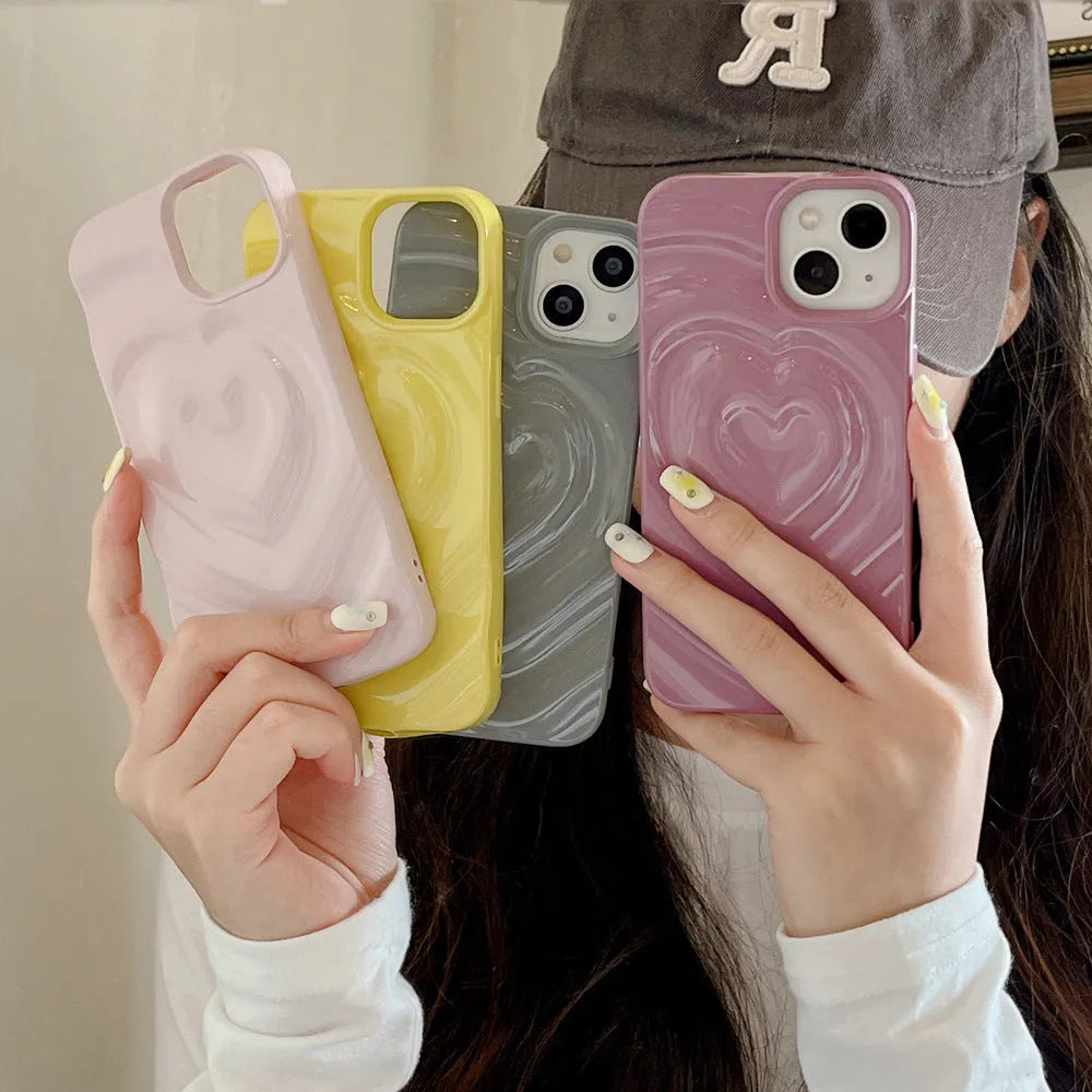 Solid colour iPhone case with a raised 3D love heart design, shown in bright purple.