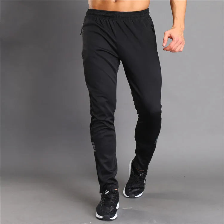 Black slim-fit running fitness trousers with reflective printing and zipper pockets on a model