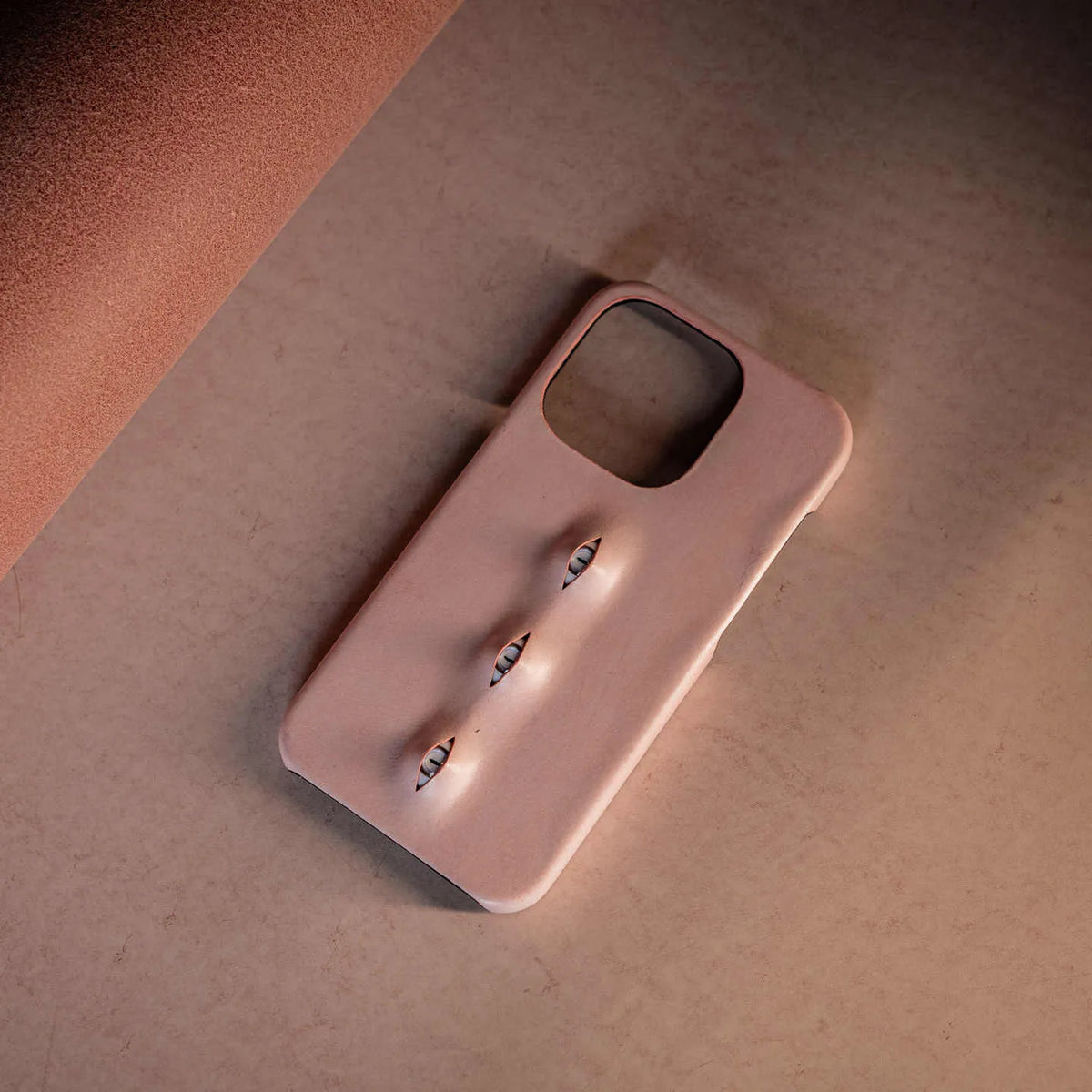 Pink eye-shaped phone case in waxed vegetable-tanned cowhide with PC bottom shell for iPhone