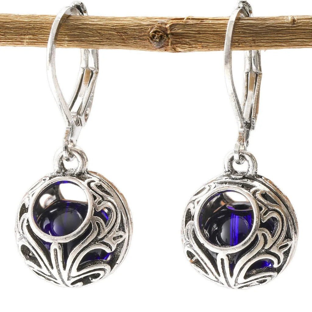 Silver tone geometric earrings with hollow pendant designs and blue gemstone accents