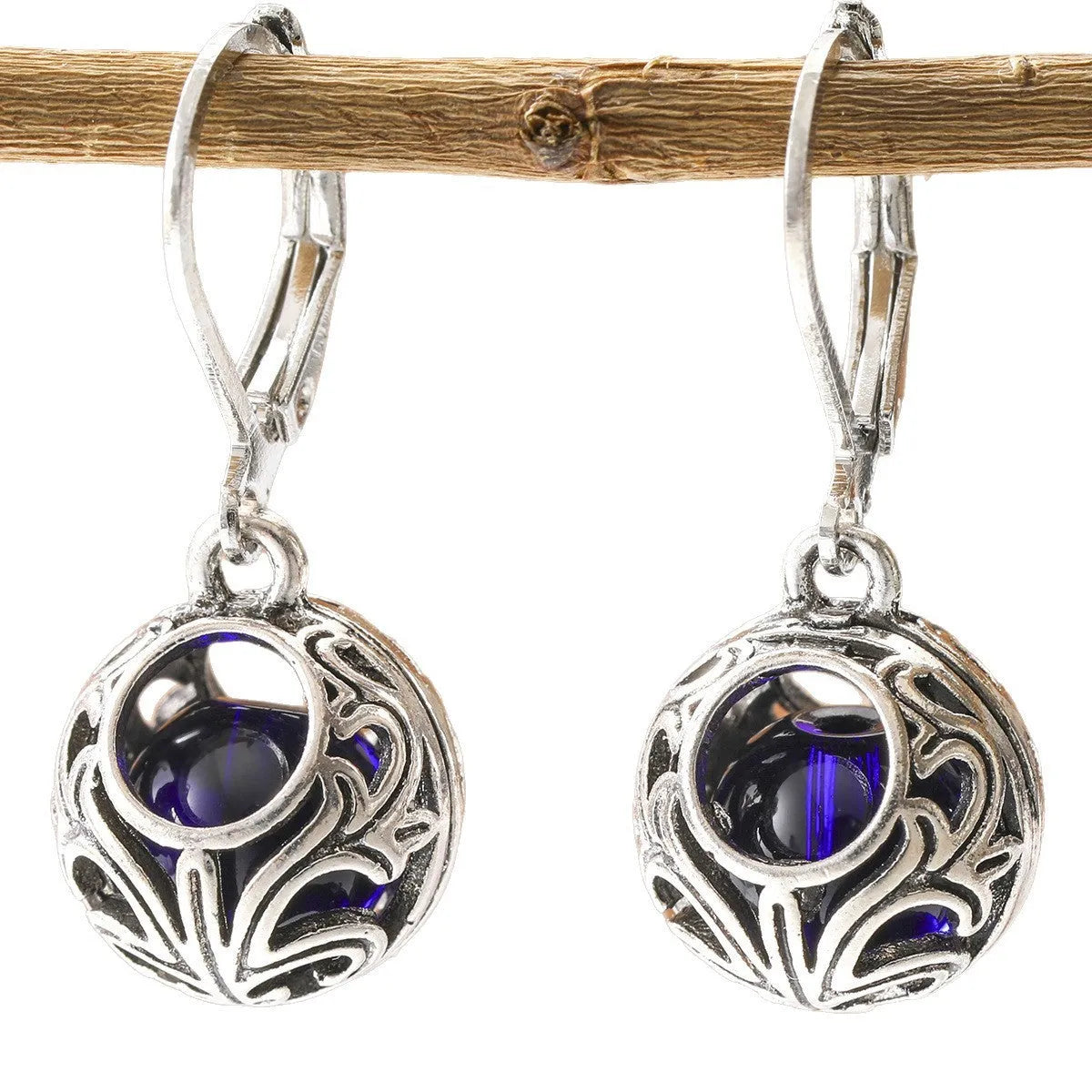 Silver tone geometric earrings with hollow pendant designs and blue gemstone accents