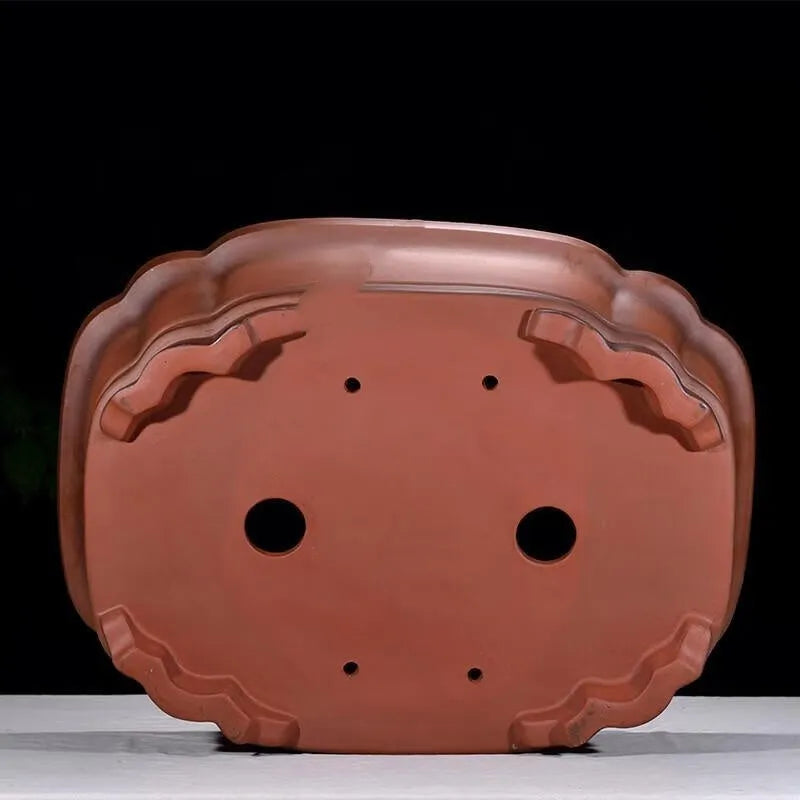 Large antique-style Chinese purple clay flowerpot with tree stump and floral relief pattern.