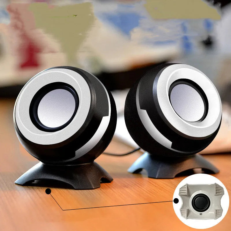 USB-powered computer stereo speakers in black gold and white gold metallic finishes beside laptop