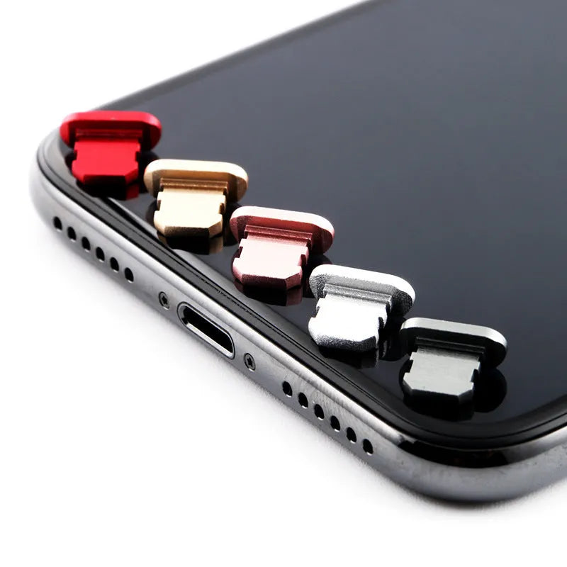 Aluminium alloy iPhone charging port dust plug in various colours on a white background.