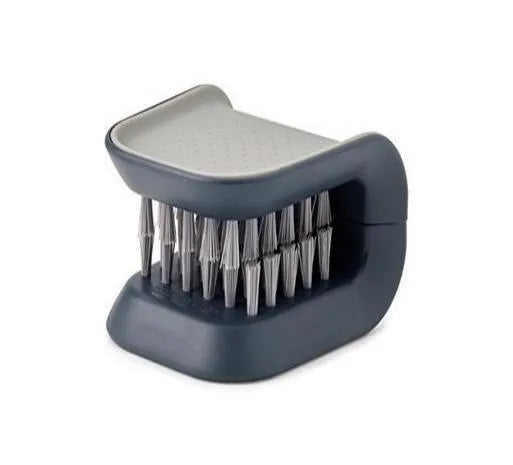 Blue U-shaped plastic brush for cleaning kitchen knives and forks on a draining board.
