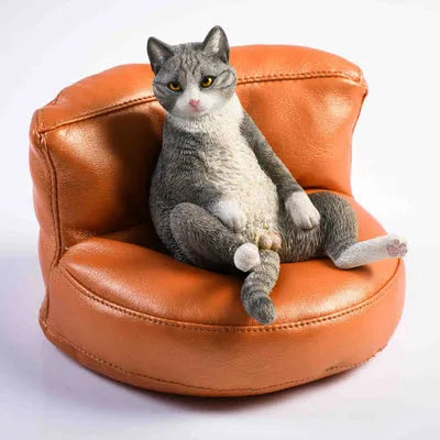 Small resin cat figurine on a sofa, a 1:6 scale car dashboard ornament.