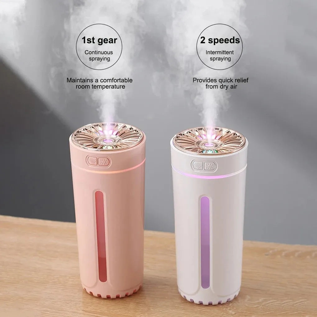 Black wireless USB car humidifier with colourful LED lights on a desktop next to a cup holder.