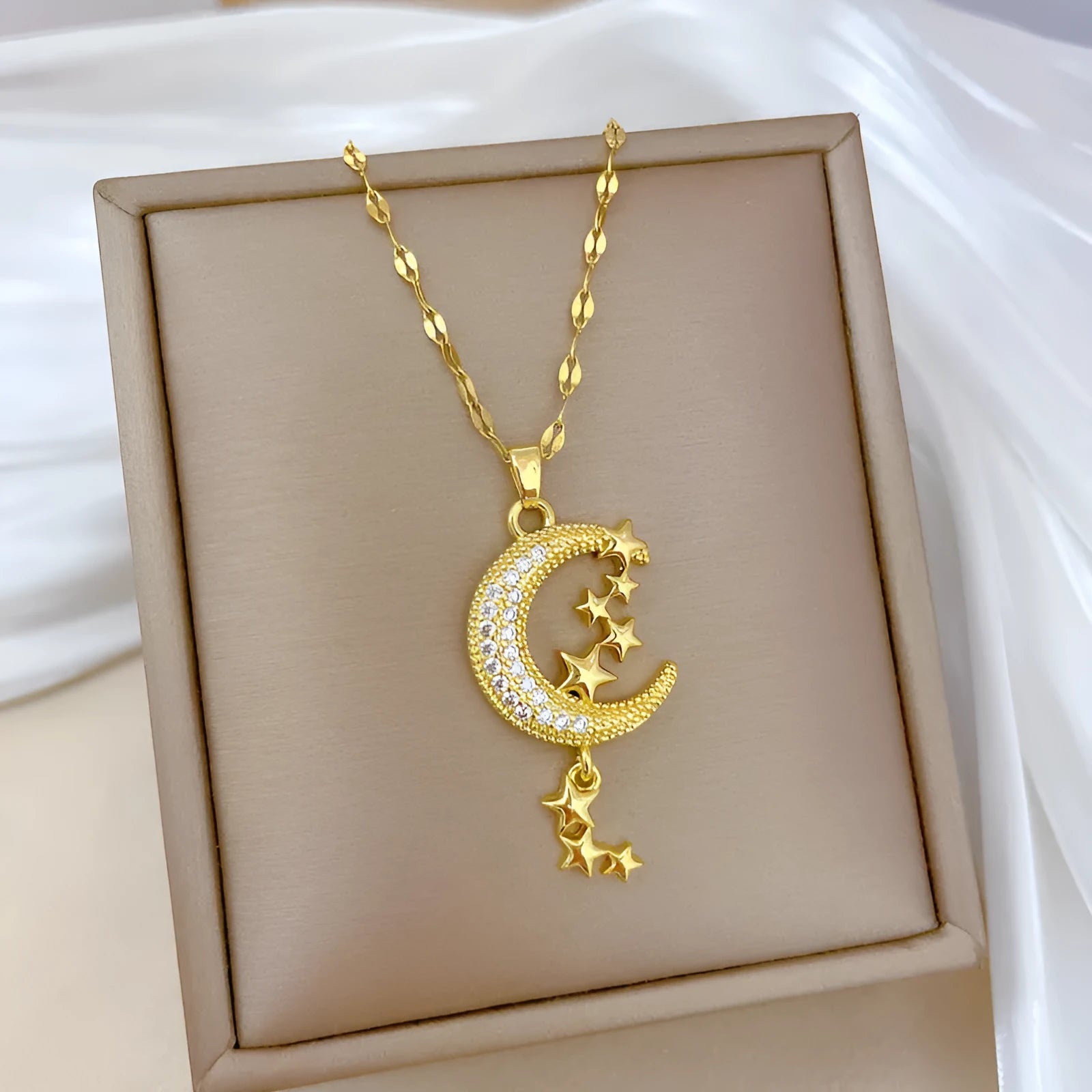 Moon tassel necklace with full diamond geometric pendant on a stainless steel chain, showing tassel detail.
