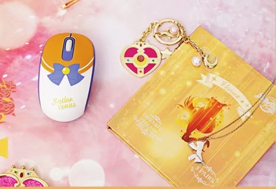 Pink Sailor Moon cartoon wireless mouse with USB receiver on a desk.