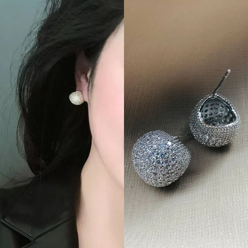 Gold and white drop-shaped geometric ear clip earrings with full diamond detailing and sphere elements