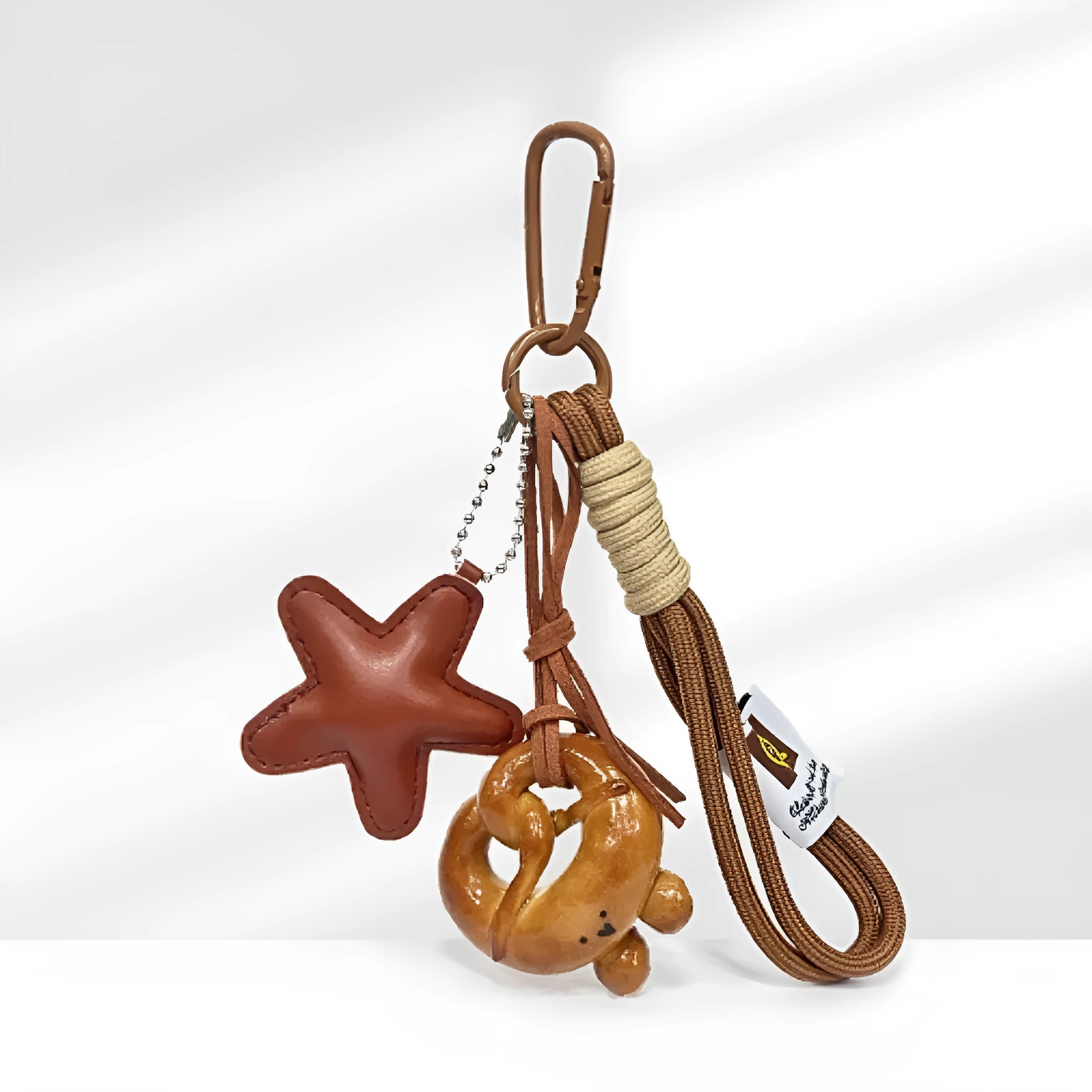 Solid brass handbag pendant featuring a handmade soda bread cartoon charm on a brown carrying strap.