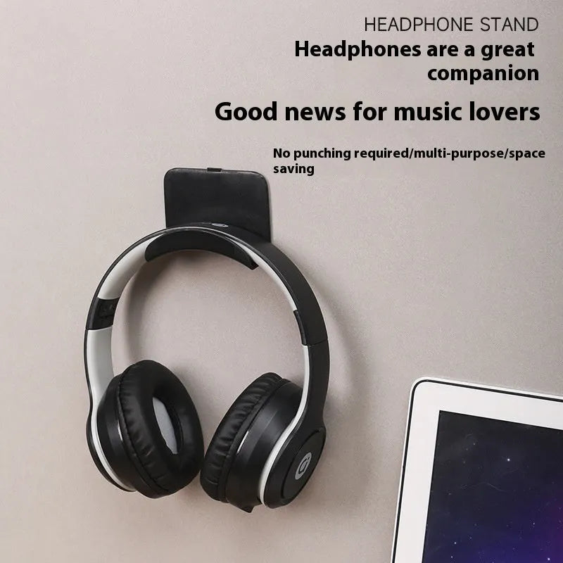 Black plastic headphone bracket mounted on wall with universal fit for headset storage