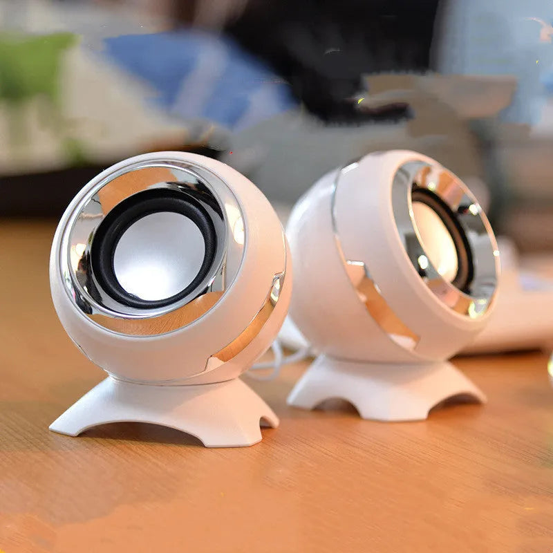 USB-powered computer stereo speakers in black gold and white gold metallic finishes beside laptop