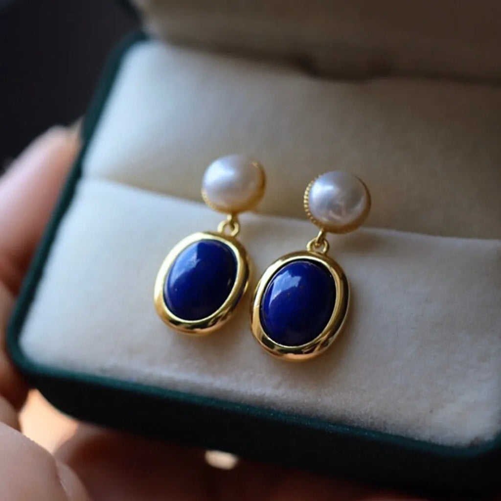 A pair of silver earrings with blue lapis lazuli pearls and auspicious patterns.