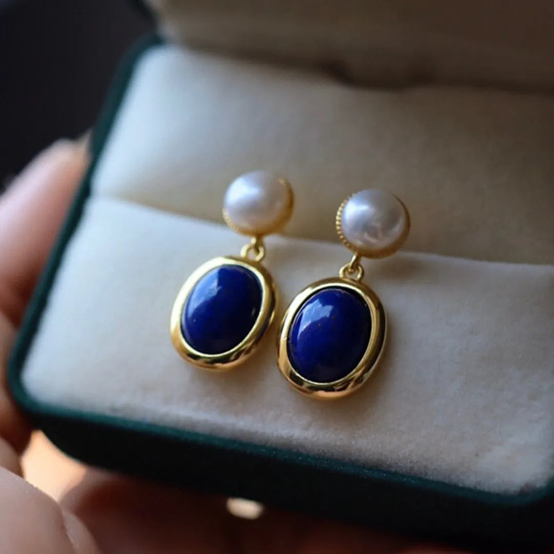 A pair of silver earrings with blue lapis lazuli pearls and auspicious patterns.