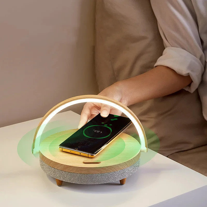 Wireless charging night light with Bluetooth speaker showing marble pattern finish and mobile phone resting in integrated holder