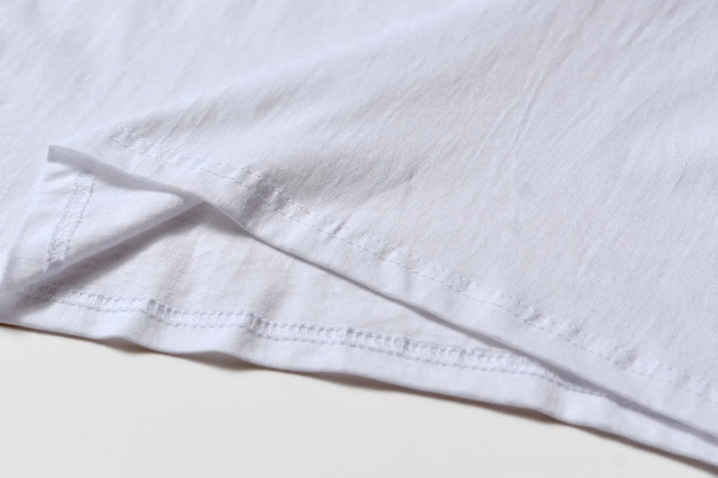 White cotton t-shirt overalls with short sleeves and a loose pullover fit
