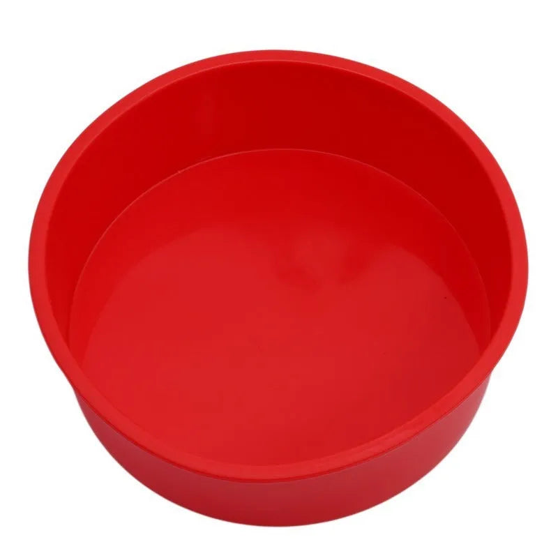 Set of three bright red round silicone cake moulds in 4-inch, 6-inch, and 8-inch sizes on a kitchen counter.