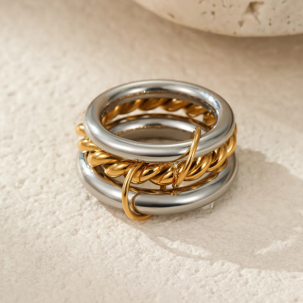 Stacked stainless steel rings with 18K gold plating in multiple colour options on a woman's hand.