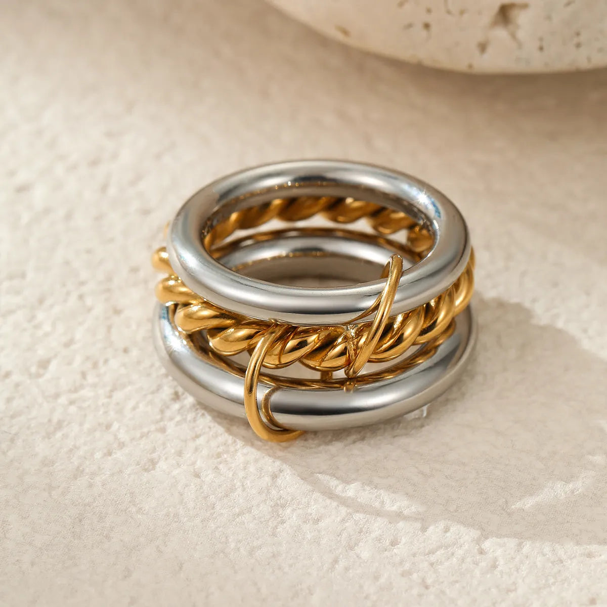 Stacked stainless steel rings with 18K gold plating in multiple colour options on a woman's hand.