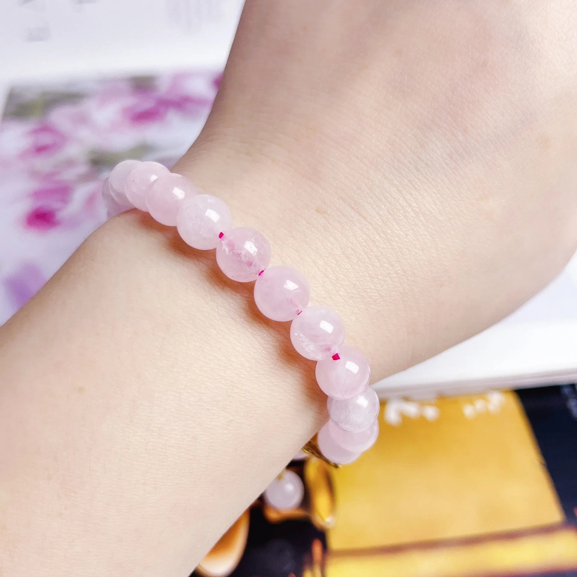 Pink crystal peach blossom bracelet with adjustable clasp on woman's wrist