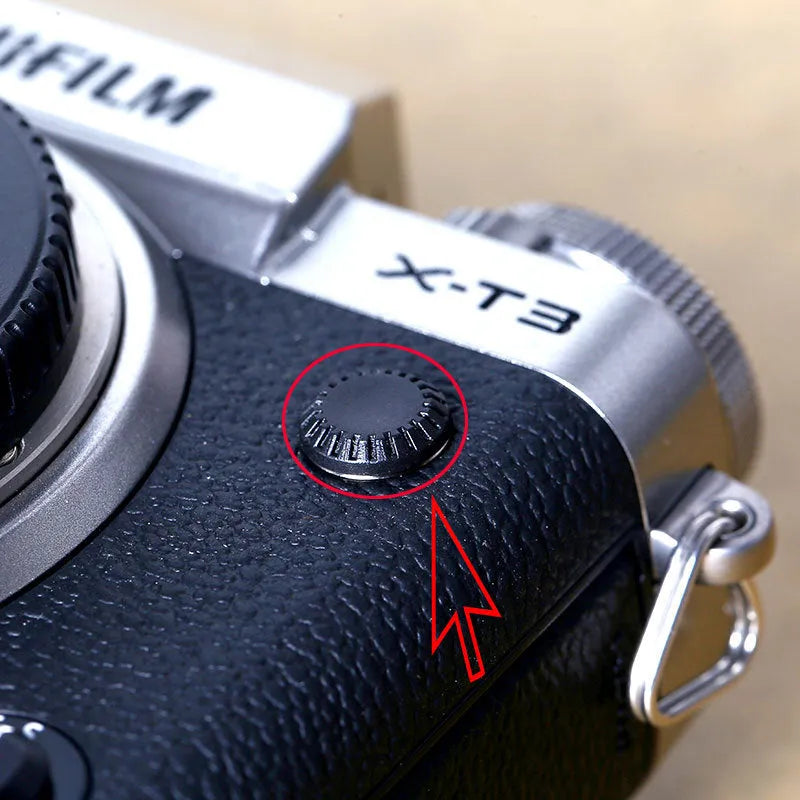 Black plastic camera shutter cover button 1cm diameter on white background