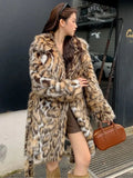 Long grey faux fur coat with a detachable fur collar and pockets on a model.