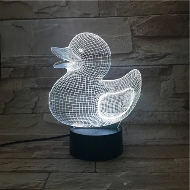 Little yellow duck 3D night light on a table, showing its cartoon design and colourful LED glow.