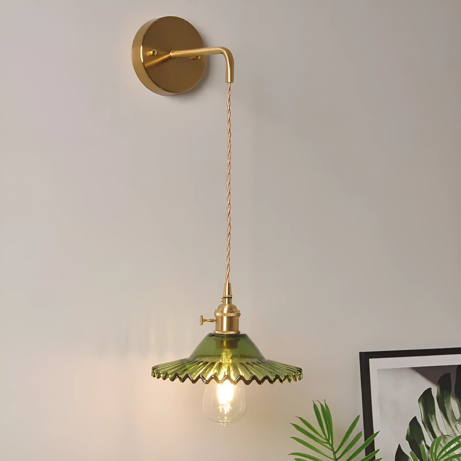 Retro brass wall lamp with a white glass lotus flower shade mounted on a beige wall.
