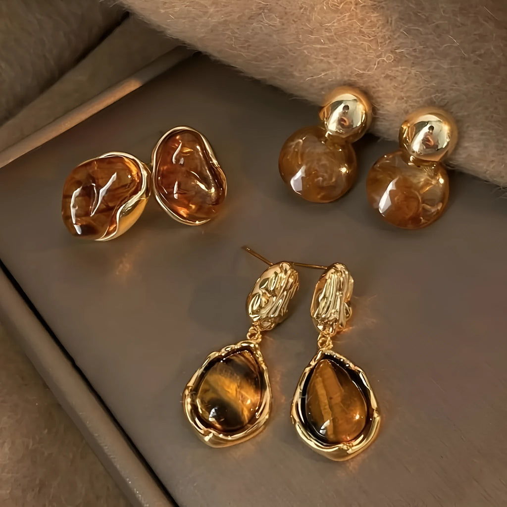 Three pairs of handmade geometric alloy earrings with tassels in Maillard, Amber, and Tigereye styles.