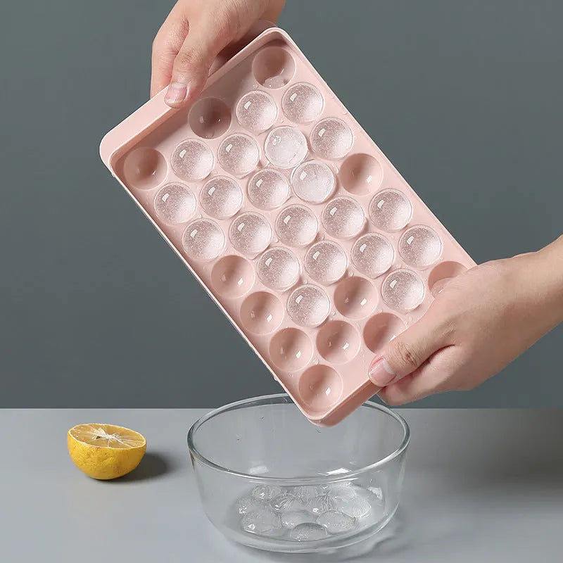 Round ball ice cube moulds in sky blue and pink creating spherical ice for drinks