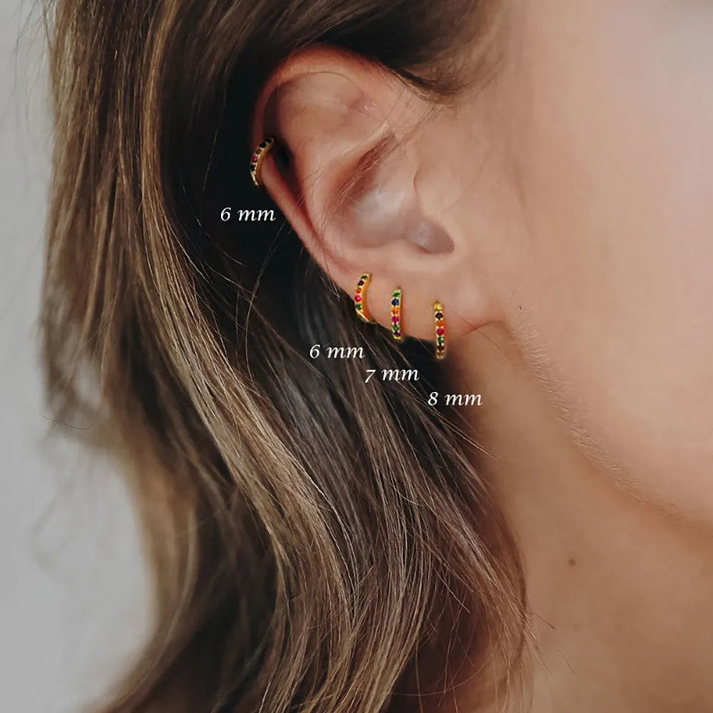 Circle-shaped cubic zirconia stud earrings in gold, rose gold, and silver colours on a white background.