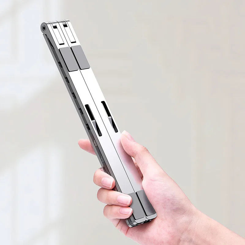 Foldable aluminium laptop stand in silver with silicone pads and cable management slot for 7-15 inch laptops