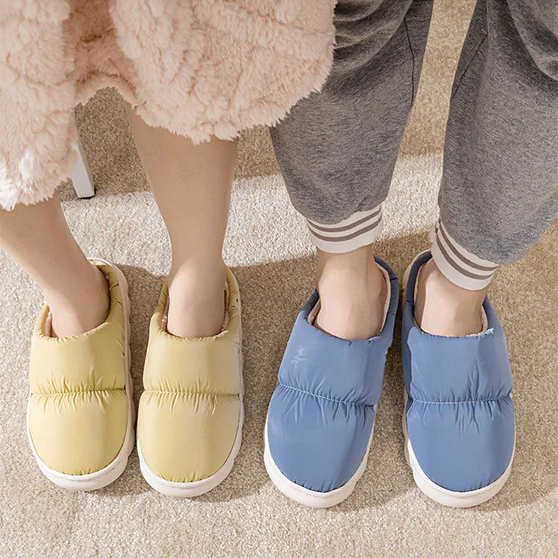 A pair of thick-soled house slippers with an artificial leather upper and plush lining, shown in a selection of colours.